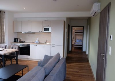 Vierbettzimmer mit Balkon Ranas B&B Rust Gesamt-Zimmerübersicht mit Küchenbereich, Tisch und Stühle sowie dem großen Couchbereich mit Tisch