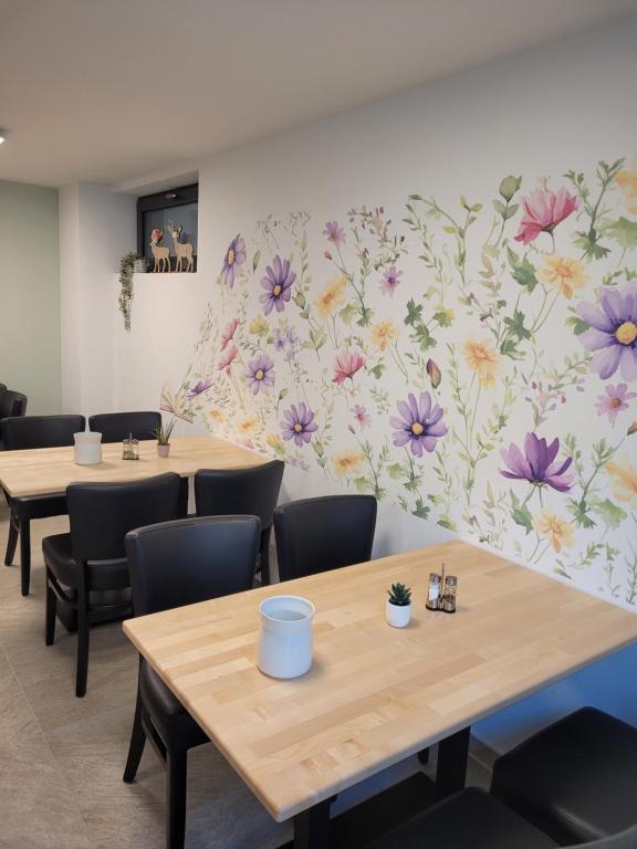 Frühstücksraum Ranas B&B Ansicht Tische und Stühle mit dekorativer Blumentapete