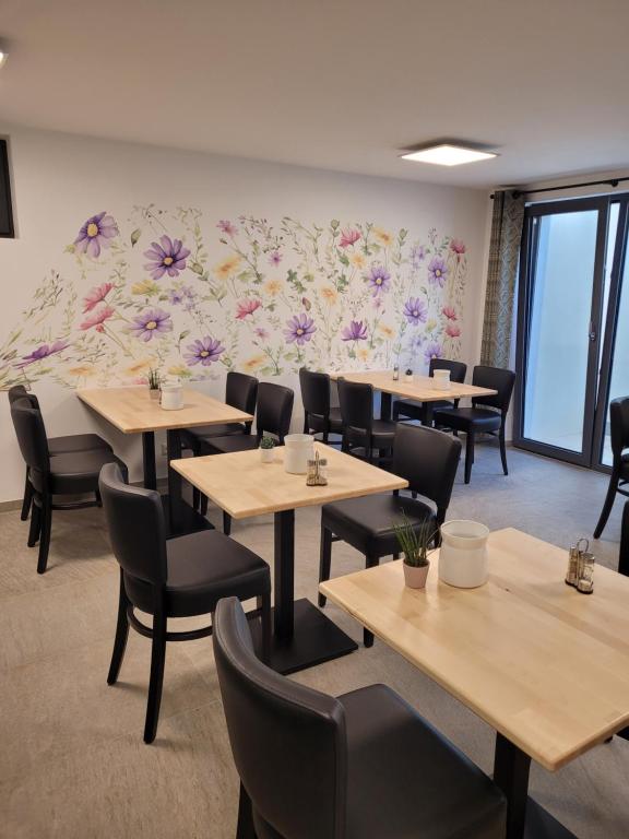 Frühstücksraum Ranas B&B Ansicht Tische und Stühle mit dekorativer Blumentapete